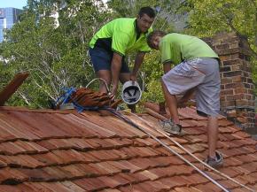 Workmen laying down the new shake roof