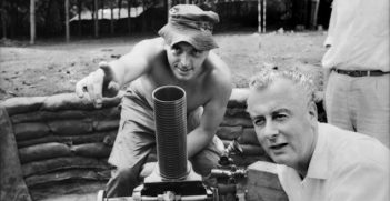 Phuoc Tuy Province, Vietnam. 1966-08. Mortar lesson for the Deputy Leader of the Federal Opposition, Mr Gough Whitlam, as he listens to one of his constituents, Lance Corporal Walter Jenkins of Warwick Farm, Sydney, NSW (left), in the mortar pit at the 5th Battalion, The Royal Australian Regiment (5RAR), during an inspection of 1st Australian Task Force installations. Image credit: Australian War Memorial Collections