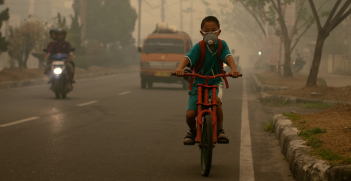 A student goes to school wearing a mask to protect him from the smoke that blankets the city of Palangka Raya, Central Kalimantan. Photo Source (Flickr) CIFOR. Creative Commons.