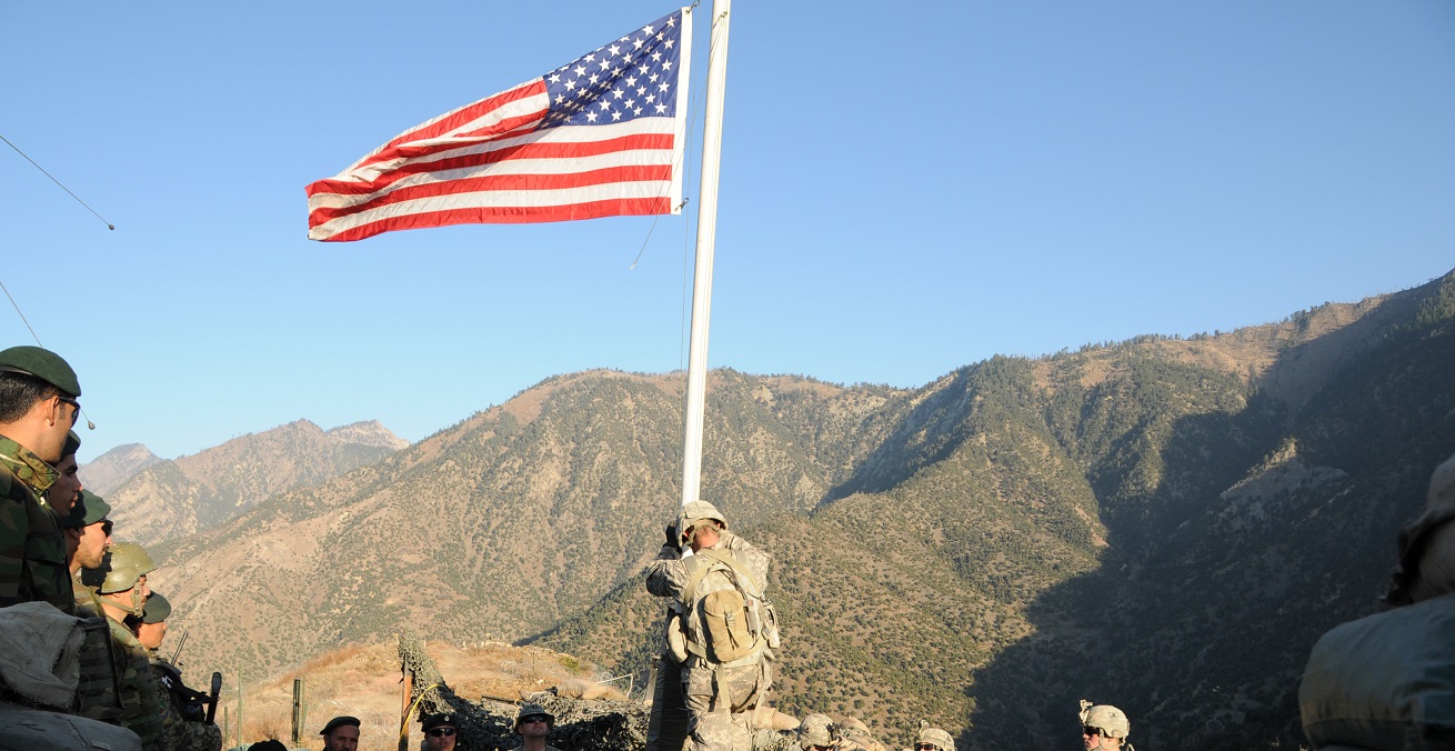 A noncommissioned officer with Troop C, 1st Squadron, 32nd Cavalary Regiment, prepares to lower the American flag during a transfer of authority ceremony at Observation Post Mace, as U.S. and Afghan National Army Soldiers look on.