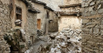 Marine in Ruined Afghan Village. Photo by Wiki Images. Source: https://bit.ly/2s4dxyl