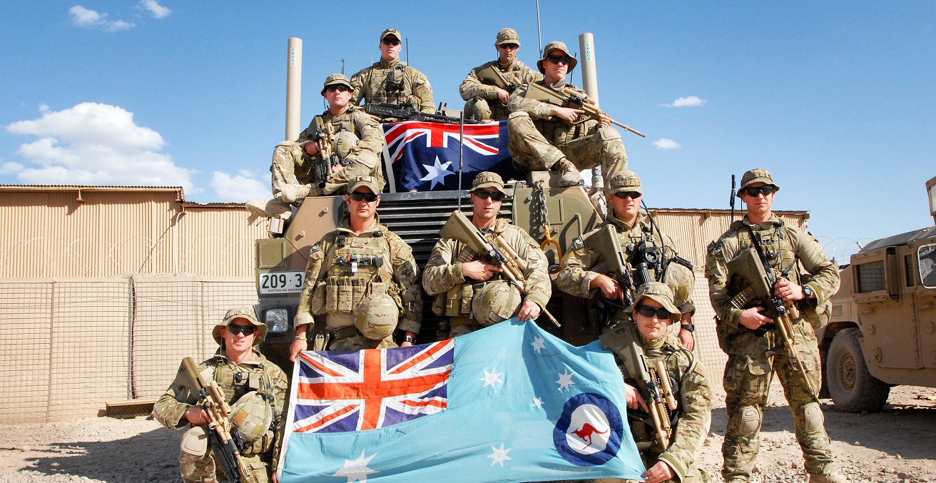 Royal Australian Air Force security force members pose with the RAAF ensign (bottom) and Commonwealth of Australia flag at Multinational Base Tarin Kot, Afghanistan. Source: U.S. Army photo by Sgt. Jessi Ann McCormick https://bit.ly/2ZM8CiK