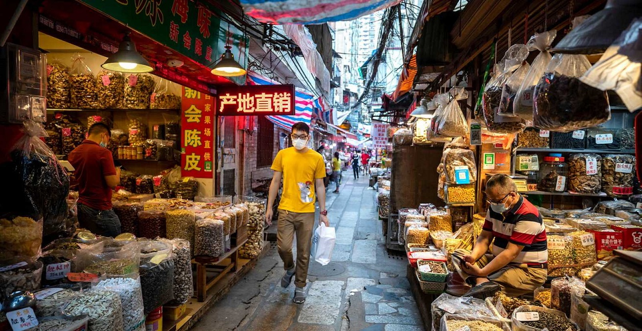 A man in a mask walks through a Guangzhou market. Source: EFE/EPA/Alex Plaveski https://bit.ly/2NJPrjW