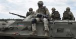 Flag of Azerbaijan on an armored personnel carrier and soldiers with machine guns. Source: Shutterstock.