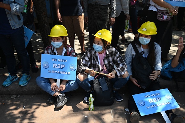 A woman holds a sign calling for 